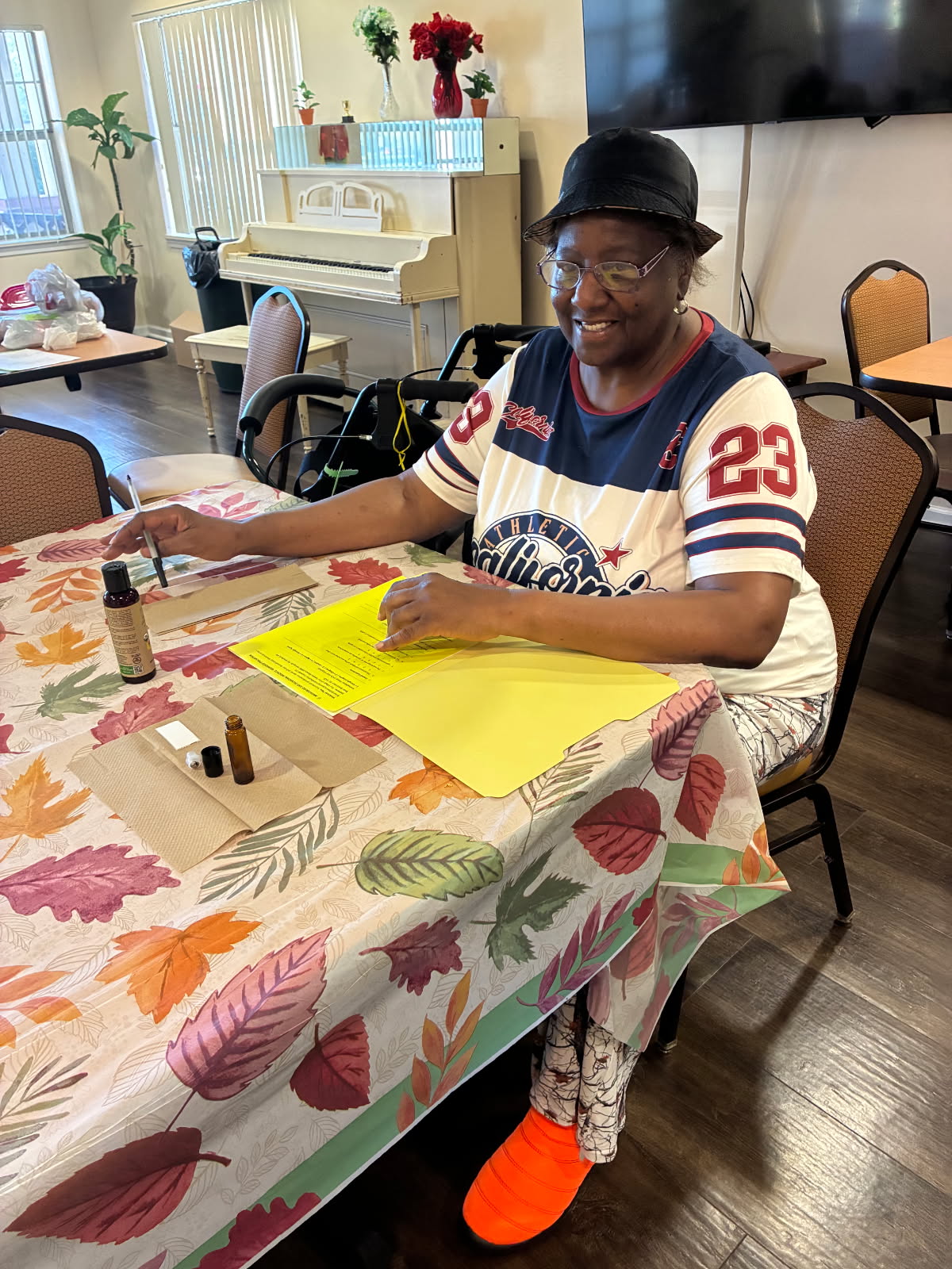 A smiling guest following along with her handout while assembling a Frankincense roller bottle